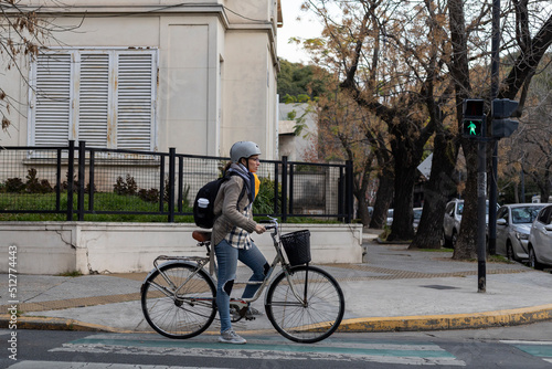 A young Latin American university student rides her vintage bicycle through the city.