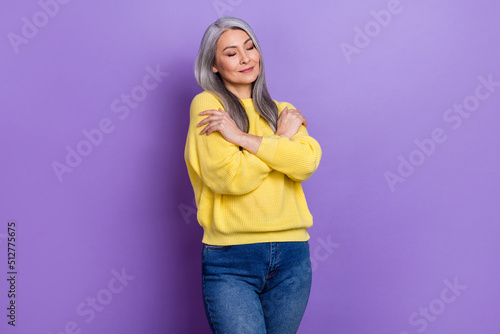 Photo of dreamy adorable retired woman wear sweater embracing herself isolated violet color background