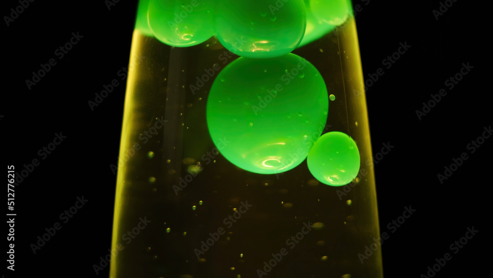 Close up view of green lava lamp isolated on black background. Concept.  Unusual lamp with dim light and moving green bubbles creating relaxing  atmosphere. foto de Stock | Adobe Stock