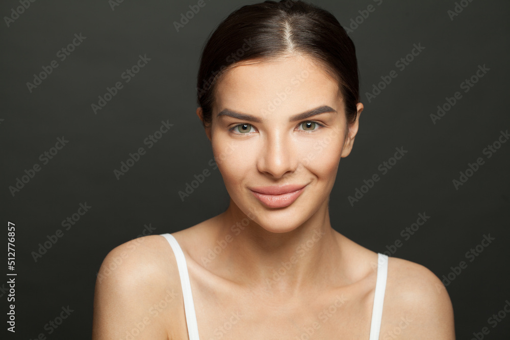 Beautiful smiling brunette woman with clean fresh skin and cute smile on black background. Female face close up. Facial treatment, cosmetology, beauty and spa concept Beautiful smiling brunette woman with clean fresh skin and cute smile on black background. Female face close up. Facial treatment, cosmetology, beauty and spa concept