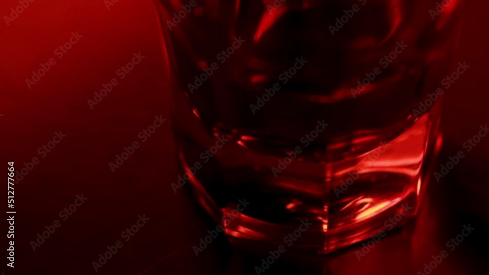 Alcohol glass with red and blue police lights, macro shot close up view. Alcohol crime and danger concept video.