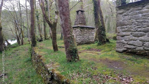 Cabin oven mountain shelter built with stones near the Sor river with forest and oaks. Camera shot traveling forward, Ponte Cubelas, Lugo, Galicia, Spain photo