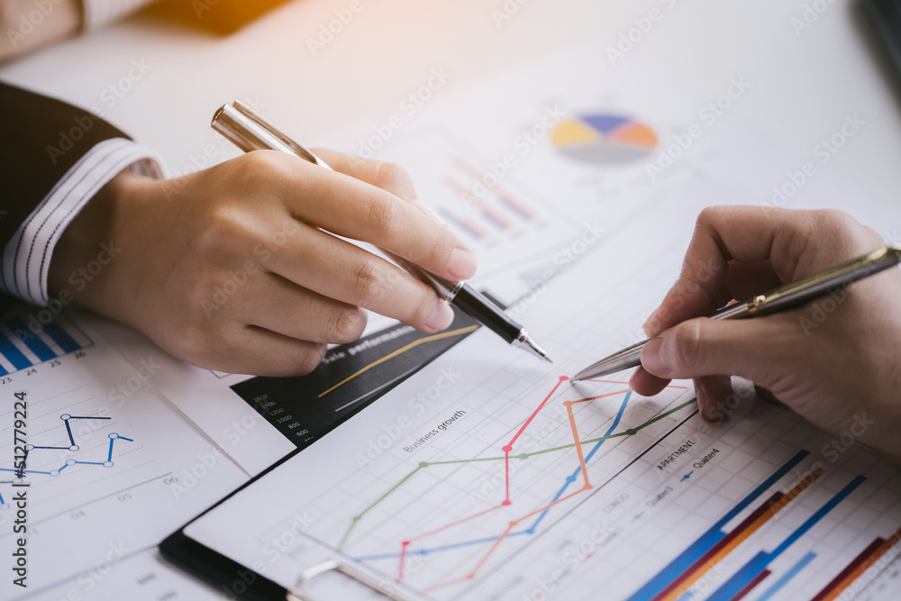 Close up of hands are working on paperworks that shows graft and chart of accounting and financial. Close up of hands are working on paperworks that shows graft and chart of accounting and financial.