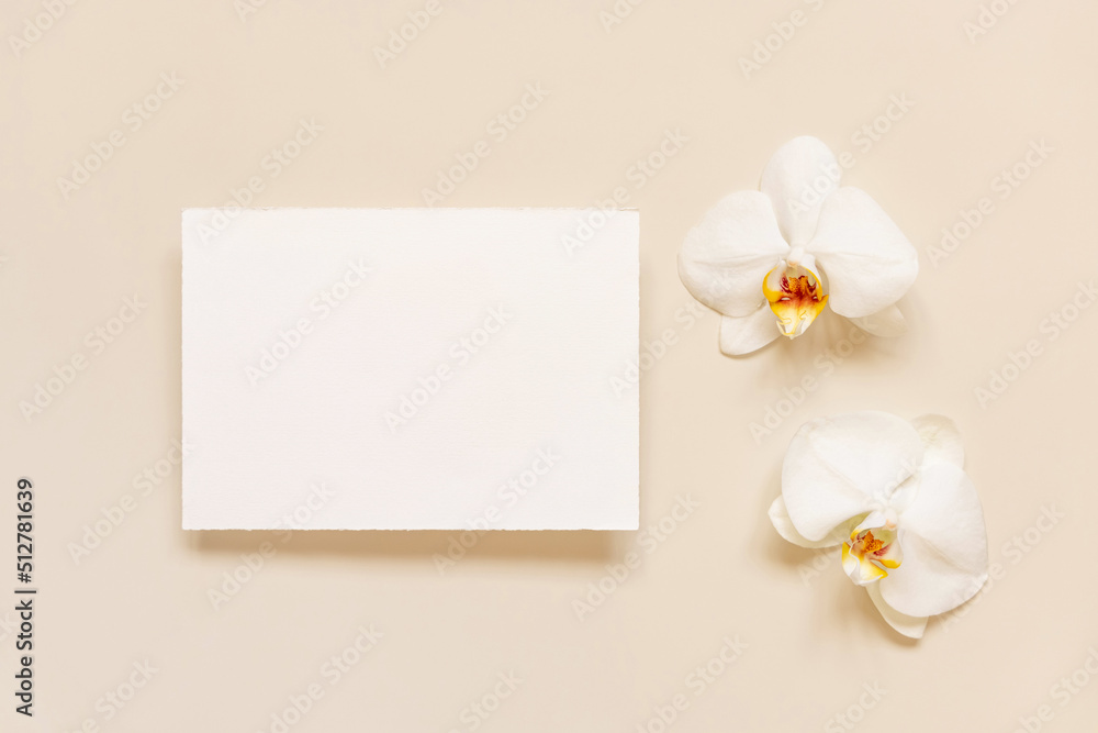 Wedding card near white orchid flowers on light yellow, mockup Wedding card near white orchid flowers on light yellow, mockup