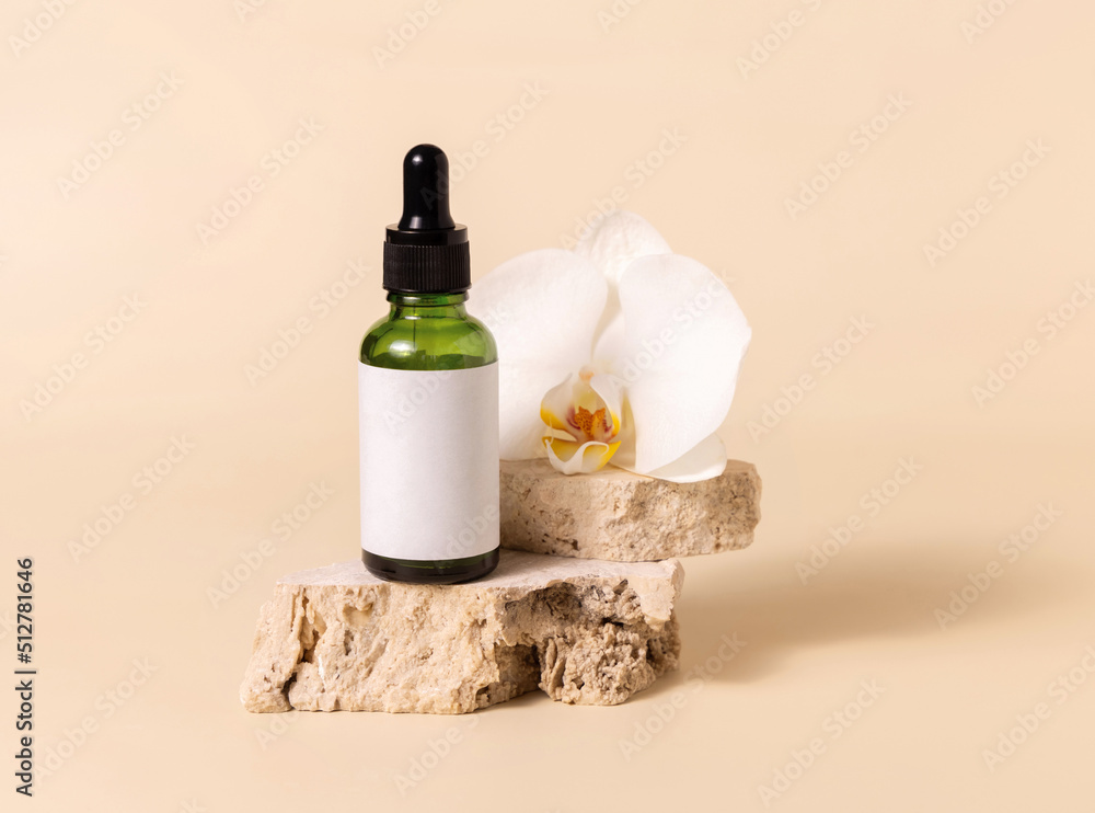 Green dropper glass bottle near white orchid flower on light yellow, Mockup. Skincare product Green dropper glass bottle near white orchid flower on light yellow, Mockup. Skincare product
