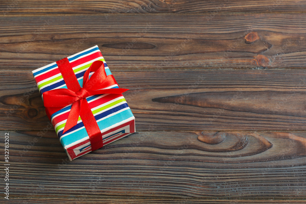 Wrapped christmas or other holiday handmade present in paper with colored ribbon. Present box, decoration of gift on table, top view with copy space Wrapped christmas or other holiday handmade present in paper with colored ribbon. Present box, decoration of gift on table, top view with copy space