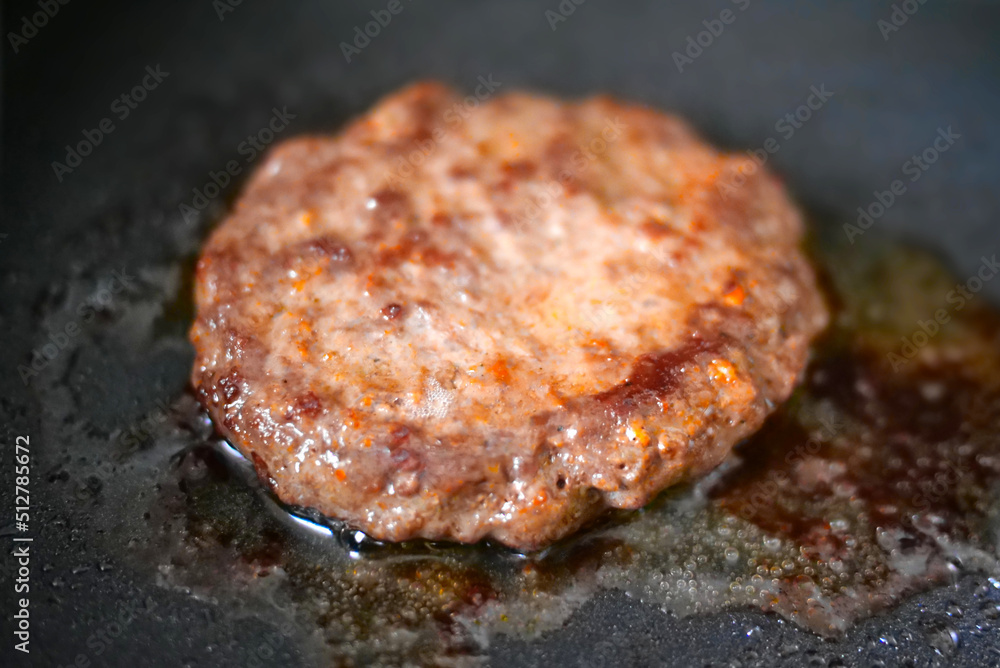 big and juicy burger cutlet fried on metal pan big and juicy burger cutlet fried on metal pan