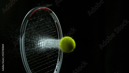 Freeze Motion Shot of Racket Hitting Tenis Ball Containing Whte Powder © Lukas Gojda