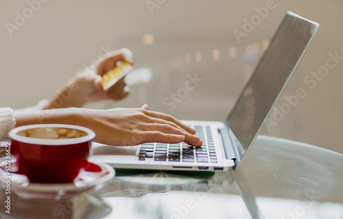Young Asian woman using credit card and mobile phone for online shopping in cafe or coworking space  coffee cup  technology money wallet and online payment concept  credit card mockup
