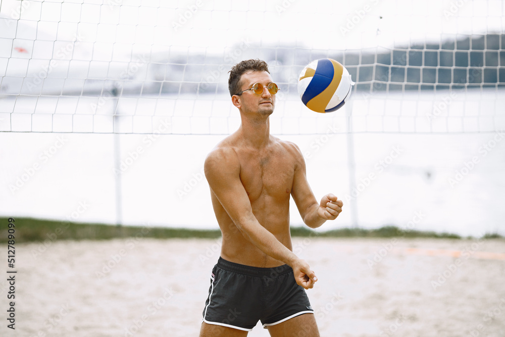 Young naked man with volleyball ball at beach Stock Photo | Adobe Stock