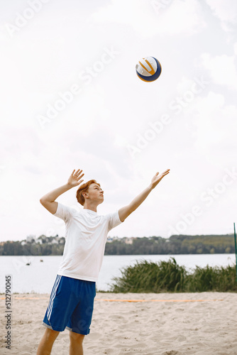 Ginger hair boy play with volleyball ball