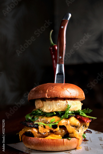 Summer double burger cut in two with cheese, tomato and vegetable.
