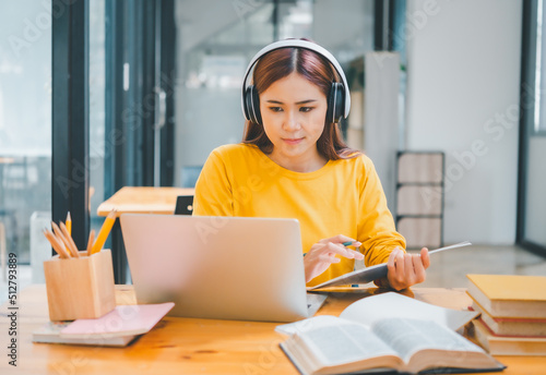  young student wearing headphones studies online, distance learning, and keeps up to date on the global coronavirus pandemic.