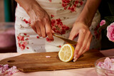 Woman is cutting lemon to tea roses petals. Aesthetic homemade natural tea rose jam preparing with sugar, lemon and tea rose petals. Healthy recipe. Lifestyle photography