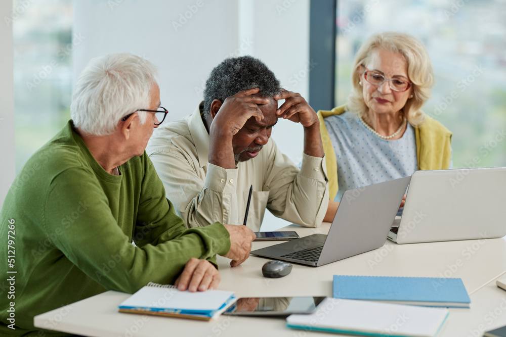 The multicultural senior students having trouble solving a web design problem on a laptop while sitting in a classroom. The multicultural senior students having trouble solving a web design problem on a laptop while sitting in a classroom.