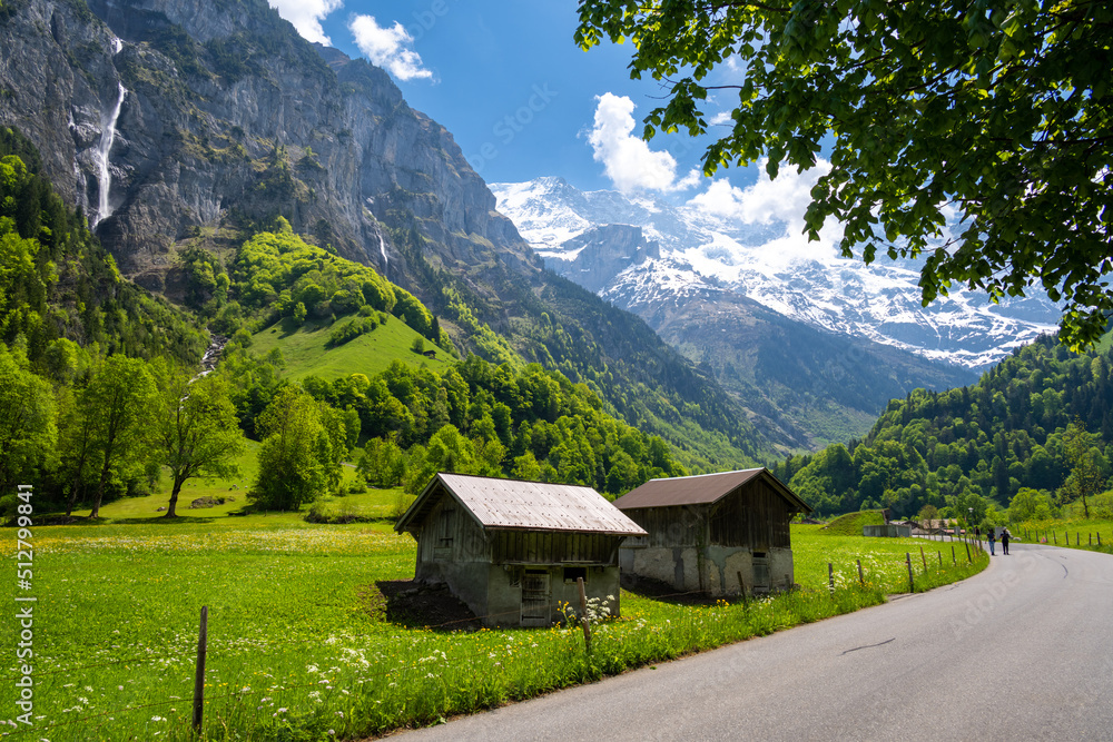amazing alpine valley with wooden huts and road in Lauterbrunnen in Switzerland