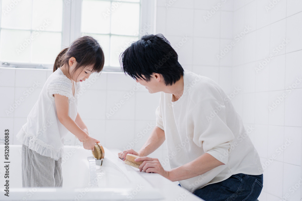 Fototapeta premium パパと一緒にお風呂掃除をする小さな女の子