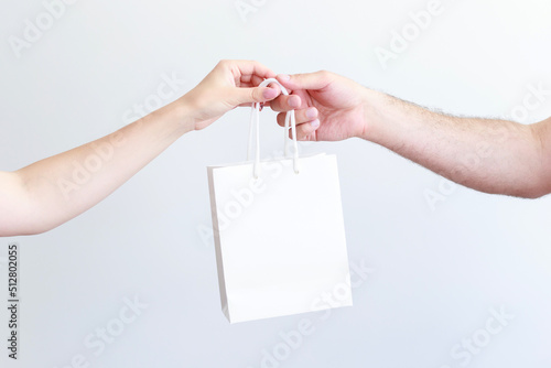 white craft bag in the hands of a man and a woman close-up
