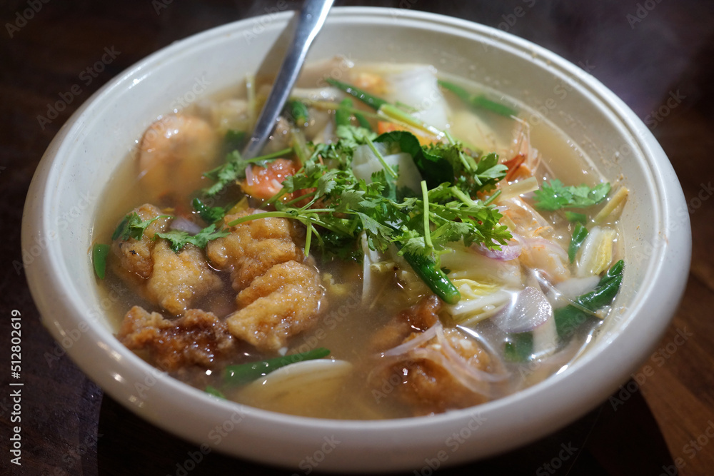 Delicious seafood Tom Yum soup.  Tom yum or tom yam is a type of hot and sour Thai soup, usually cooked with Seafood. Soft focus, high angle view image.