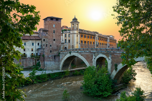 Εκτύπωση καμβά Picturesque evening cityscape of the Tiber river, Fabrizio bridge and Castello Caetani Castle on the Isola Tiberina island in Rome at sunset