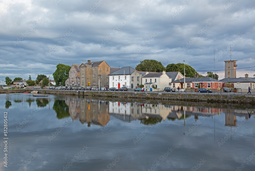 Skyline of housing in Galway reflected in the River Corrib at dusk