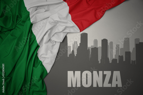abstract silhouette of the city with text Monza near waving national flag of italy on a gray background.