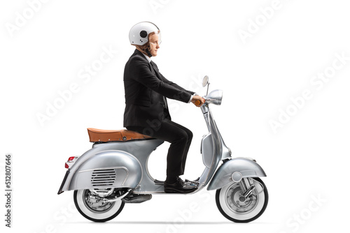 Mature businessman with a helmet riding a vintage scooter