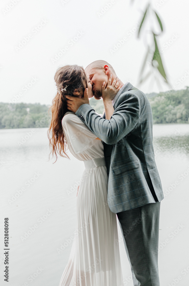 brides kissing on the background of the lake
