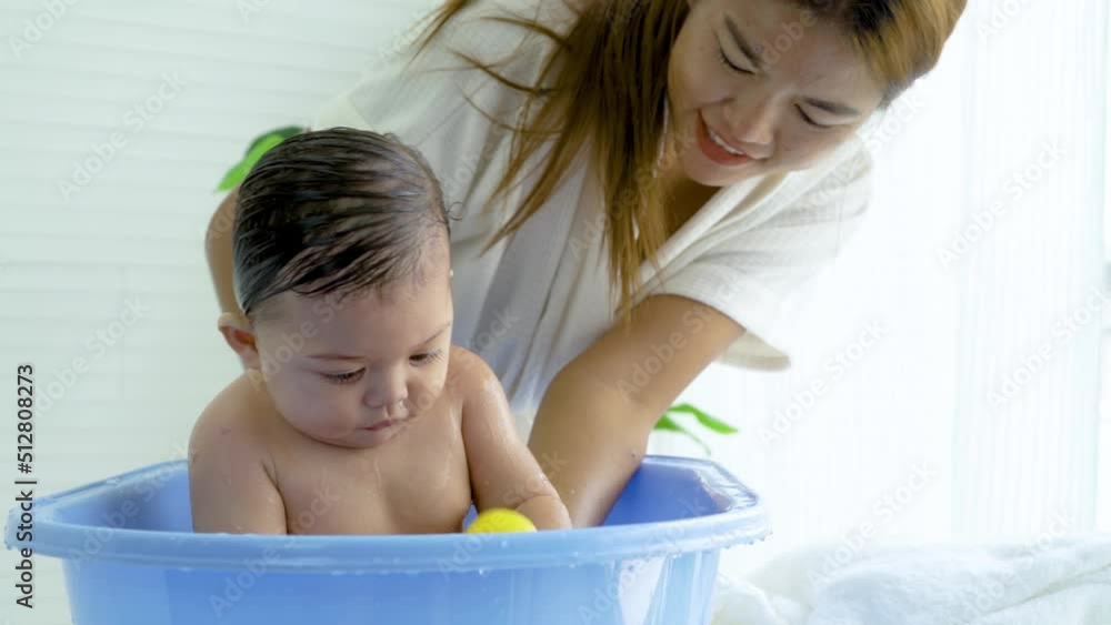 Hygienic procedures for newborn, Mother bathing her daughter in warm water, Bathing the baby in the bathroom. Newborn takes a bath in bathtub, Baby girl smile happy face while take shower Hygienic procedures for newborn, Mother bathing her daughter in warm water, Bathing the baby in the bathroom. Newborn takes a bath in bathtub, Baby girl smile happy face while take shower
