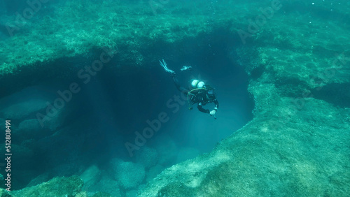 Female scuba diver near the exit from the cave. Cave diving in Mediterranean Sea, Cyprus