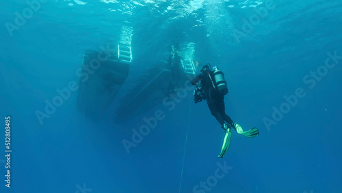 Scuba diver swim towards diving boat in blue water. Mediterranean Sea, Cyprus