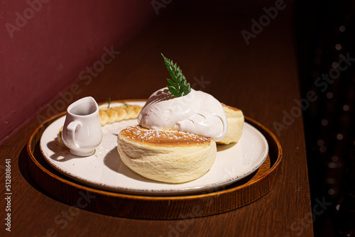 souffle pancake dessert with cream served on a white plate
