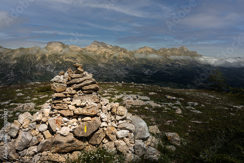 Stone cairn or way marker with peaks in background in Alps  France