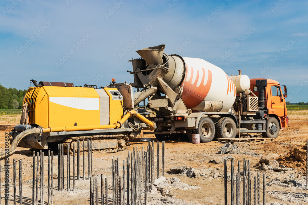 Concrete mixer truck delivers concrete to the pump for pouring piles. Concrete pump at the construction site. Close-up of concrete delivery.