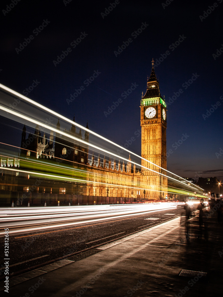 Big Ben at night, London. Long exposure traffic streaming by the famous Big Ben and Houses of Parliament landmarks.