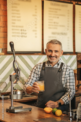 Man holding glass of juice smiling at camera