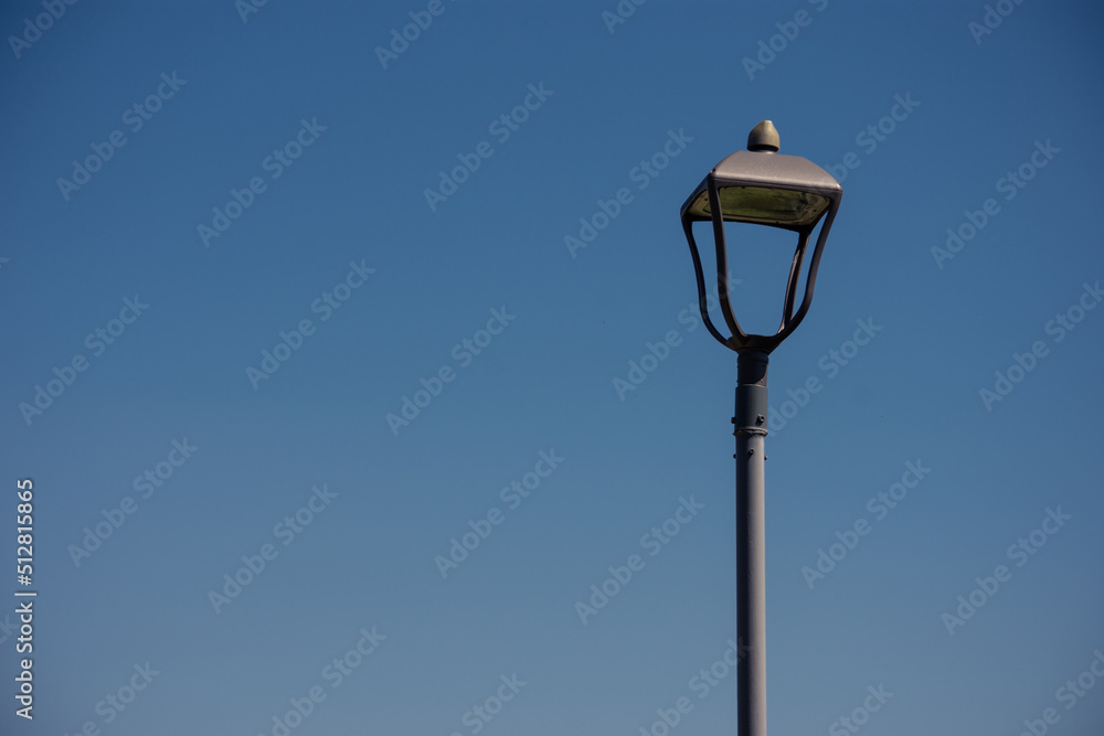 Vintage design of an empty metallic street light against blue sky