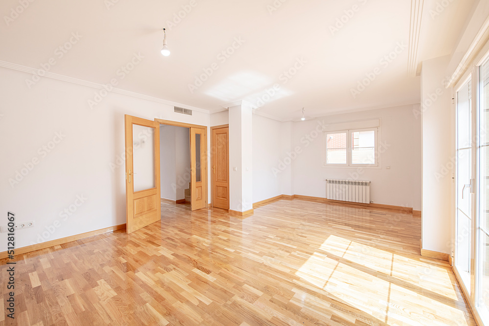 Empty living room with glossy French oak parquet and matching joinery Empty living room with glossy French oak parquet and matching joinery