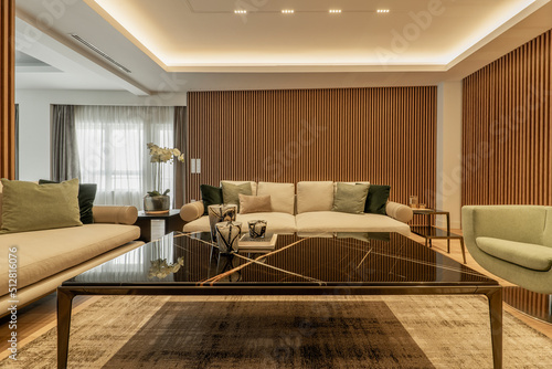 Luxury design living room large coffee table in black marble  wood on the walls  matching rugs and armchairs with cushions