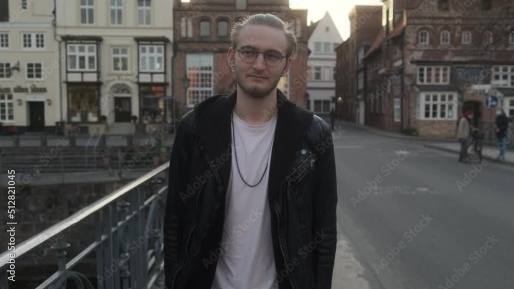 Young European Man with Leather Jacket and Glasses walking on Bridge Young European Man with Leather Jacket and Glasses walking on Bridge