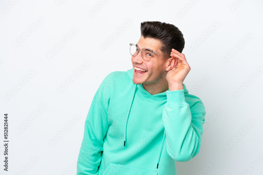 Young handsome caucasian man isolated on white bakcground listening to something by putting hand on the ear Young handsome caucasian man isolated on white bakcground listening to something by putting hand on the ear