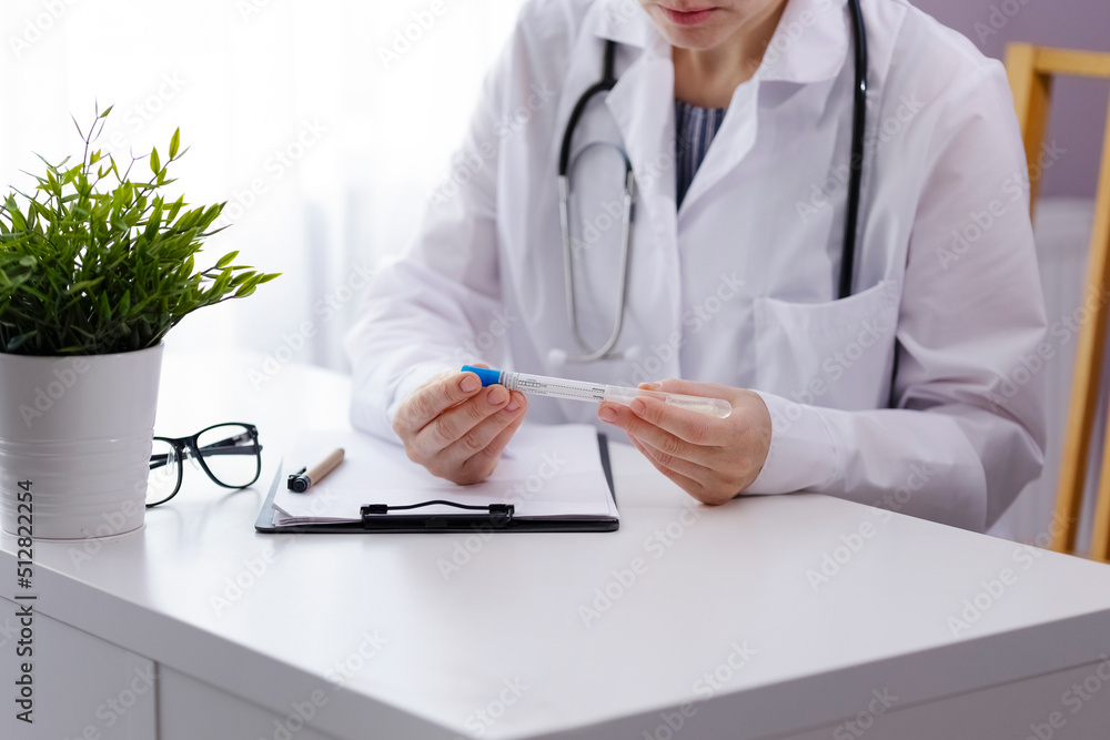 A woman doctor in a white patch sits at a table A woman doctor in a white patch sits at a table