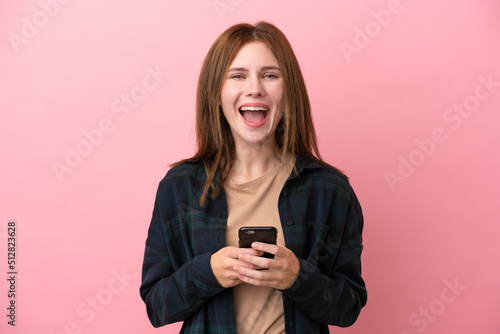 Young English woman isolated on pink background surprised and sending a message