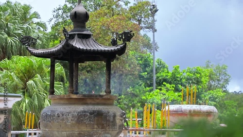 A stationary footage of a large incense burner called Jokoro where tourists rush to as the smoke rises from it. This landmark is located at the Buddhist Temple, Po Lin Monastery, in Hong Kong. photo