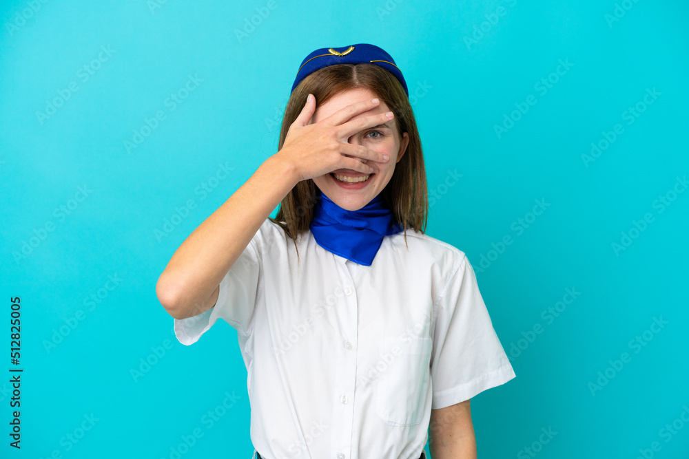 Airplane stewardess English woman isolated on blue background covering eyes by hands and smiling Airplane stewardess English woman isolated on blue background covering eyes by hands and smiling
