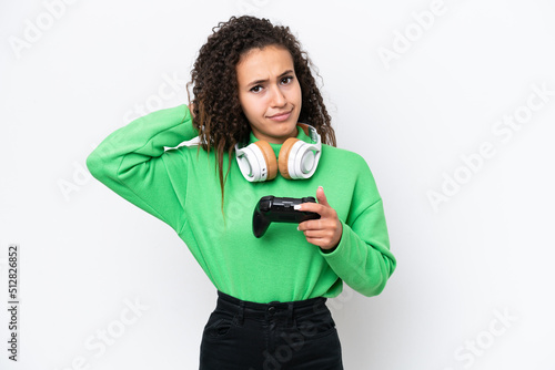 Young Arab woman playing with a video game controller isolated on white background having doubts