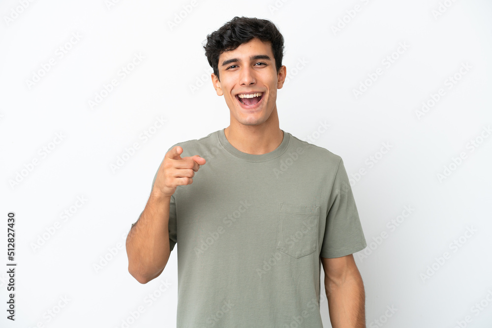 Young Argentinian man isolated on white background surprised and pointing front Young Argentinian man isolated on white background surprised and pointing front