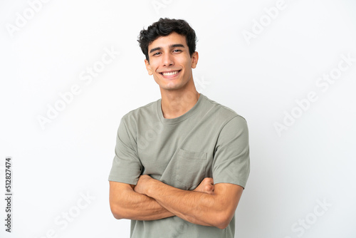 Young Argentinian man isolated on white background with arms crossed and looking forward