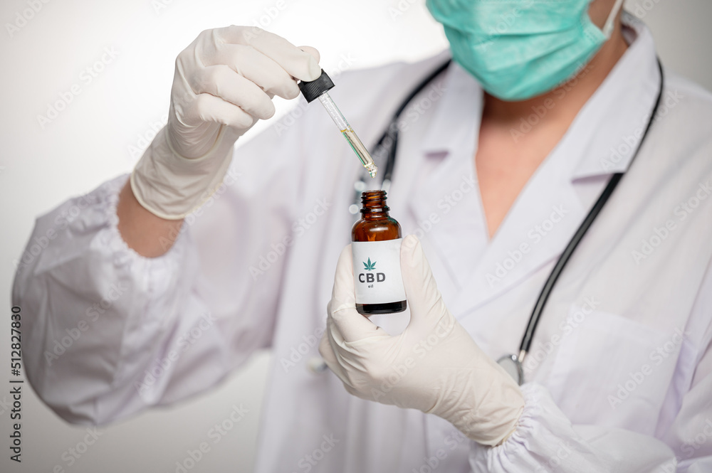 close up Medical technologist looks at a bottle of CBD oil. Research on cannabis extracts. Sleep supplement. Medical marijuana. vitamins and supplements healthy alternatives. close up Medical technologist looks at a bottle of CBD oil. Research on cannabis extracts. Sleep supplement. Medical marijuana. vitamins and supplements healthy alternatives.