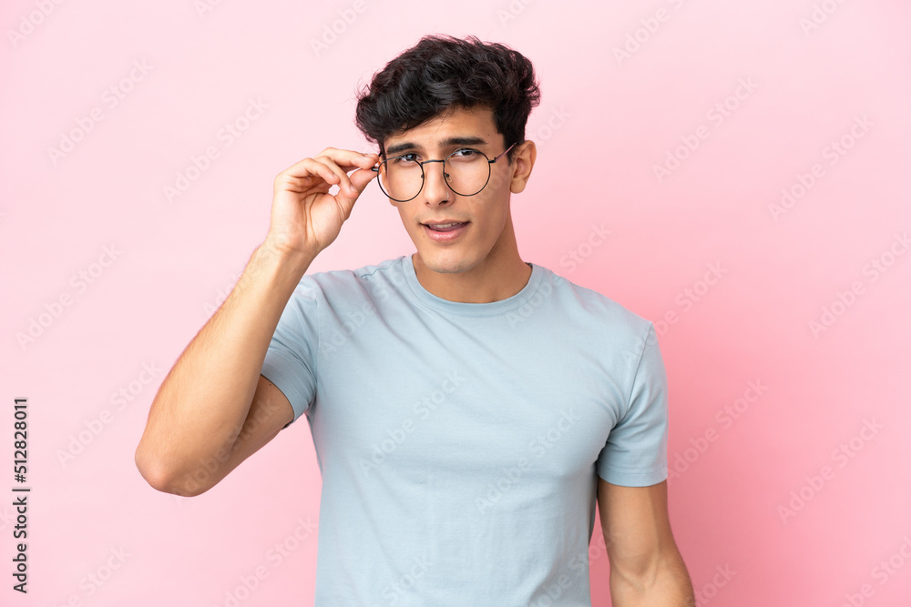 Young Argentinian man isolated on pink background With glasses and frustrated expression Young Argentinian man isolated on pink background With glasses and frustrated expression